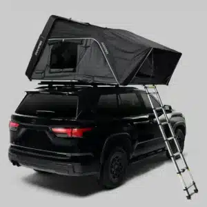 Black SUV with a roof-mounted camping tent fully extended and a metal ladder leaning alongside the vehicle