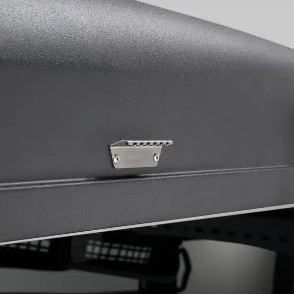 Small metal latch mounted on a textured black panel or case.